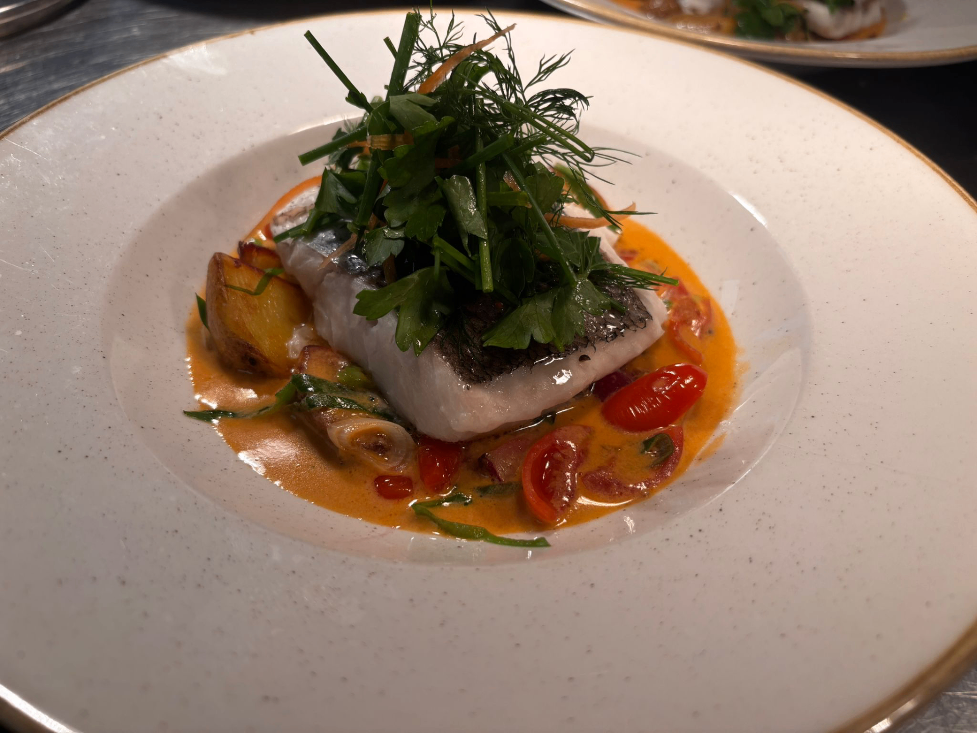 Pan-seared white fish in a creamy tomato sauce with herbs